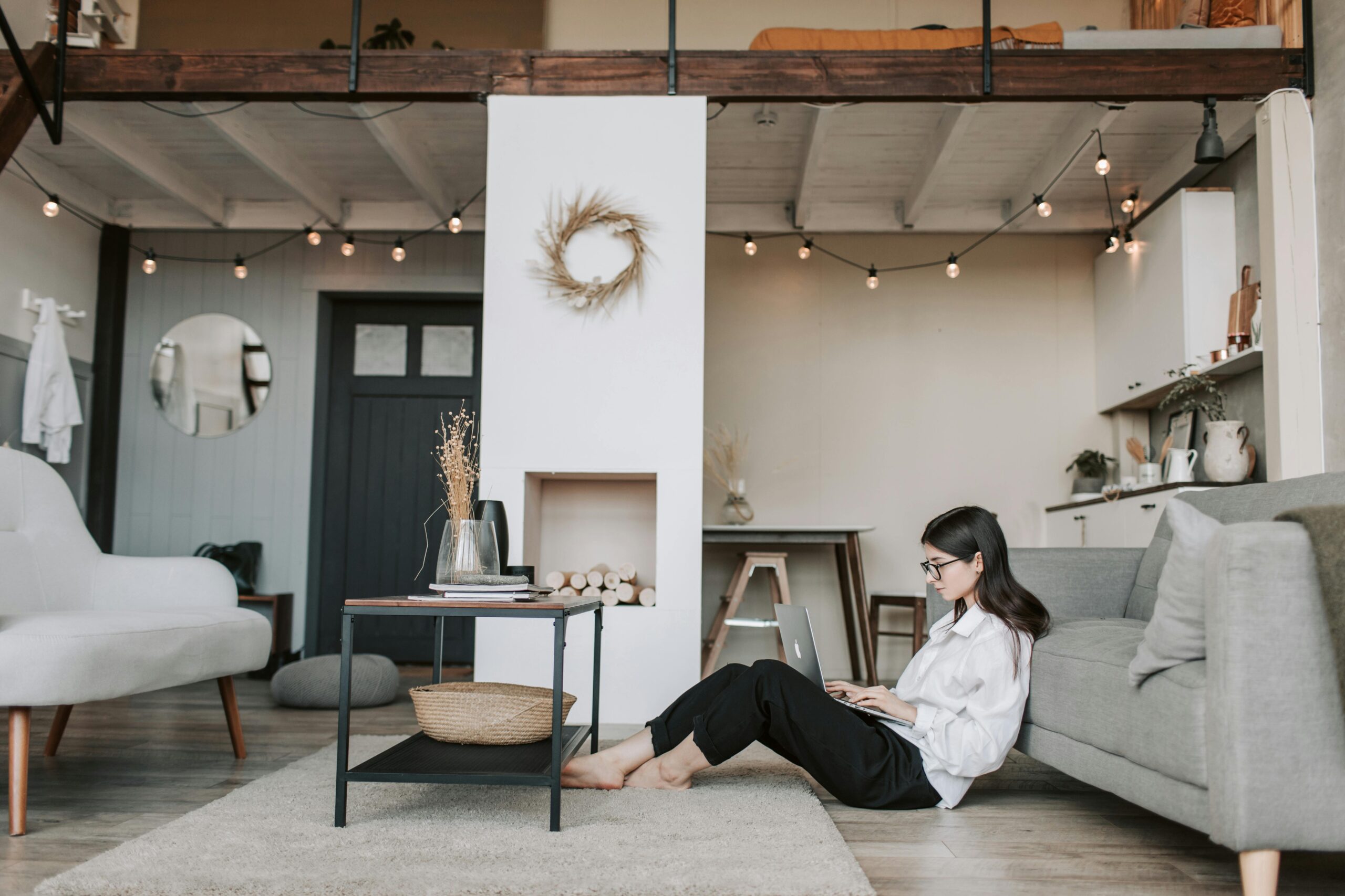 A person sitting on the floor of their loungeroom, working on a laptop