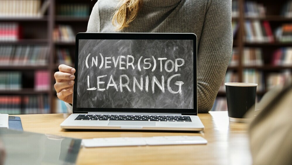 A laptop with the words (N)EVER (S)TOP LEARNING