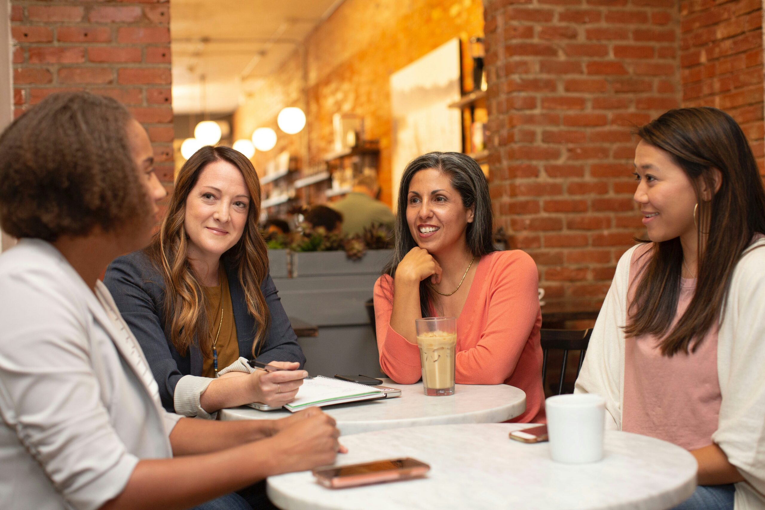 A group of people sitting around a table, having a conversation