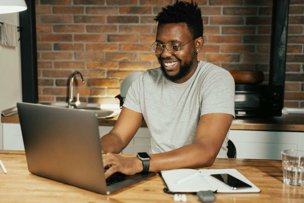 A Man Looking Happy At Home, Working On His Laptop