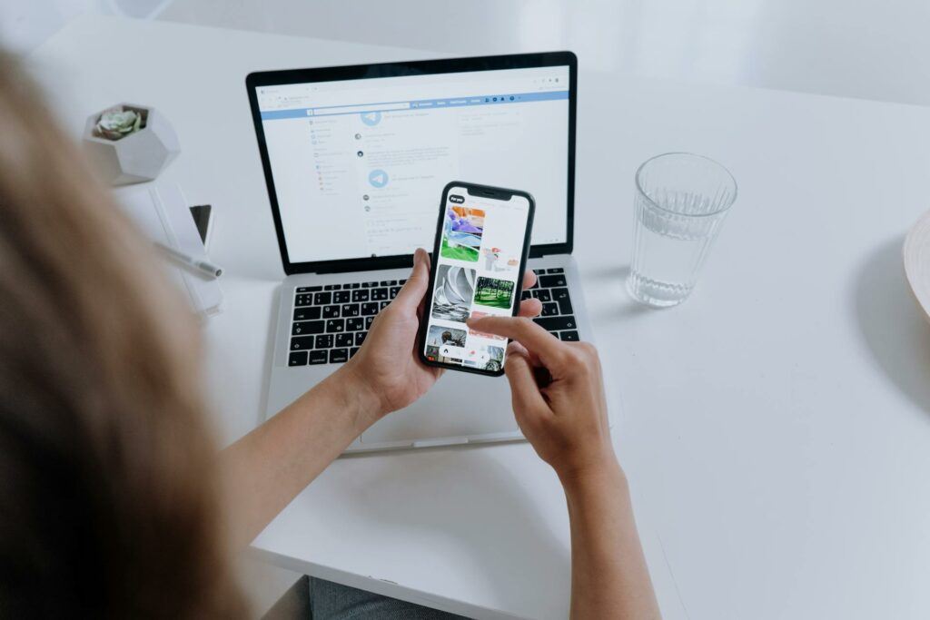 A person holding a mobile phone, scrolling through images