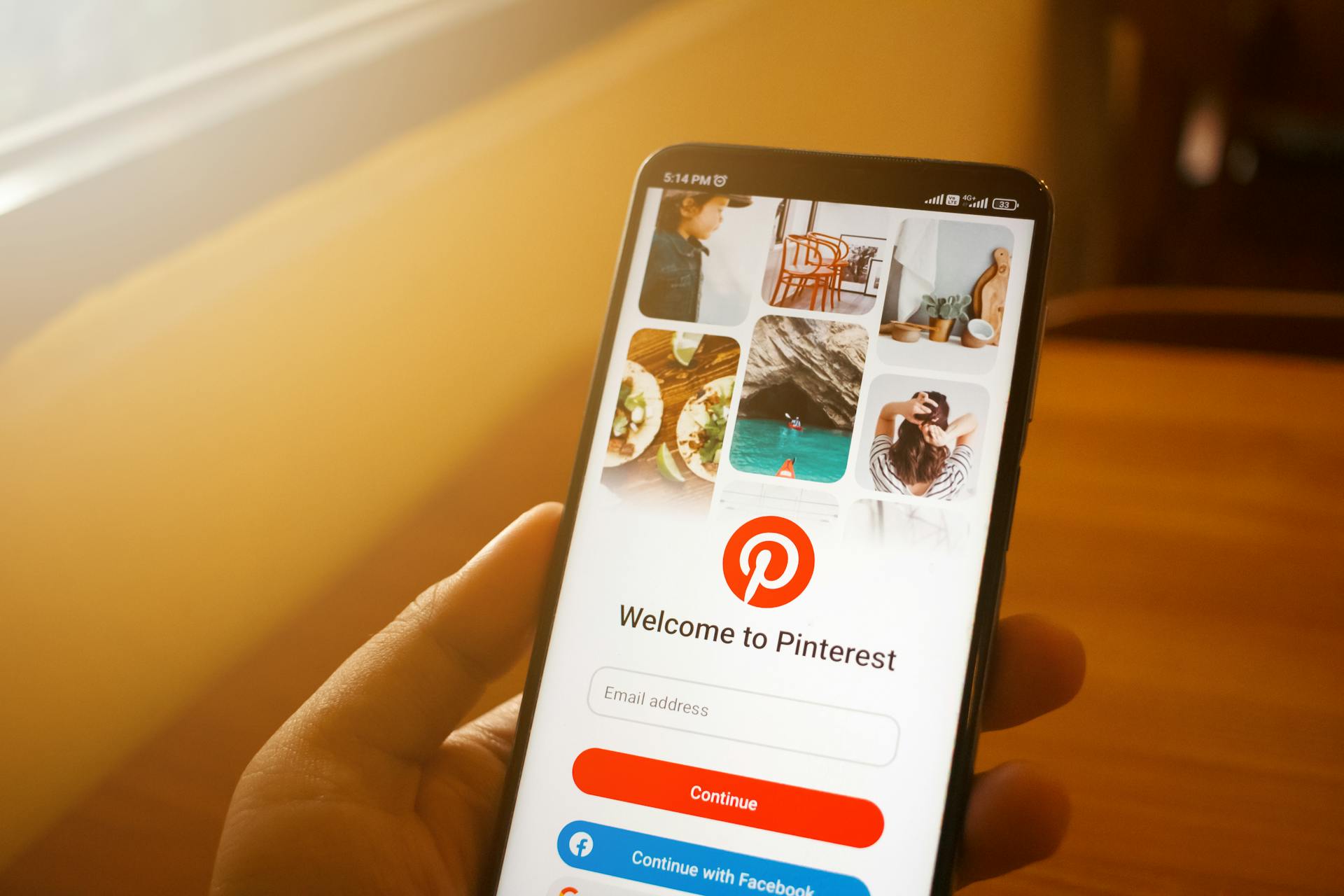 A person holding a phone with the Pinterest app on it